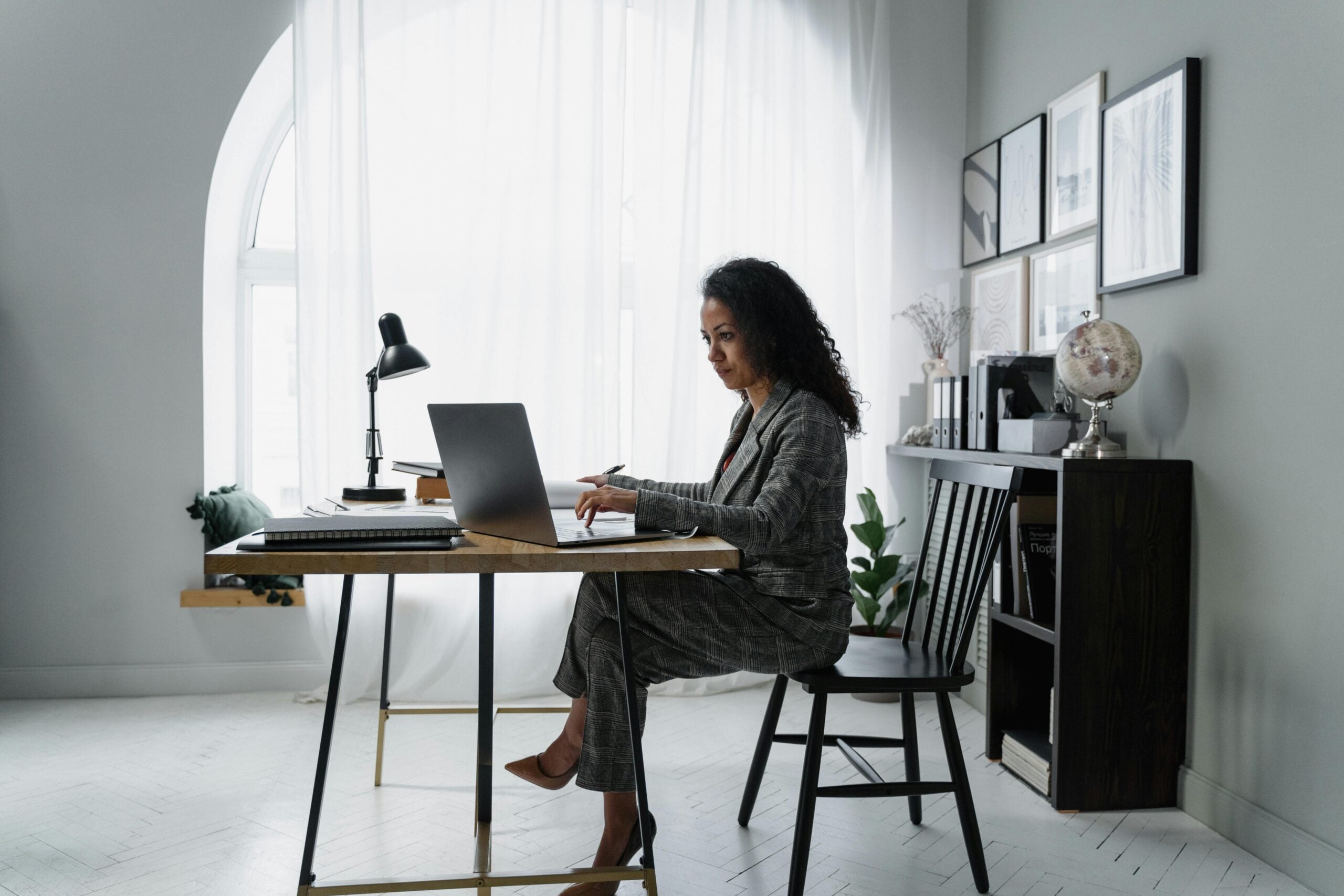 Businesswoman at desk reviewing financial data on a computer, illustrating small business cash management and the Profit First method.